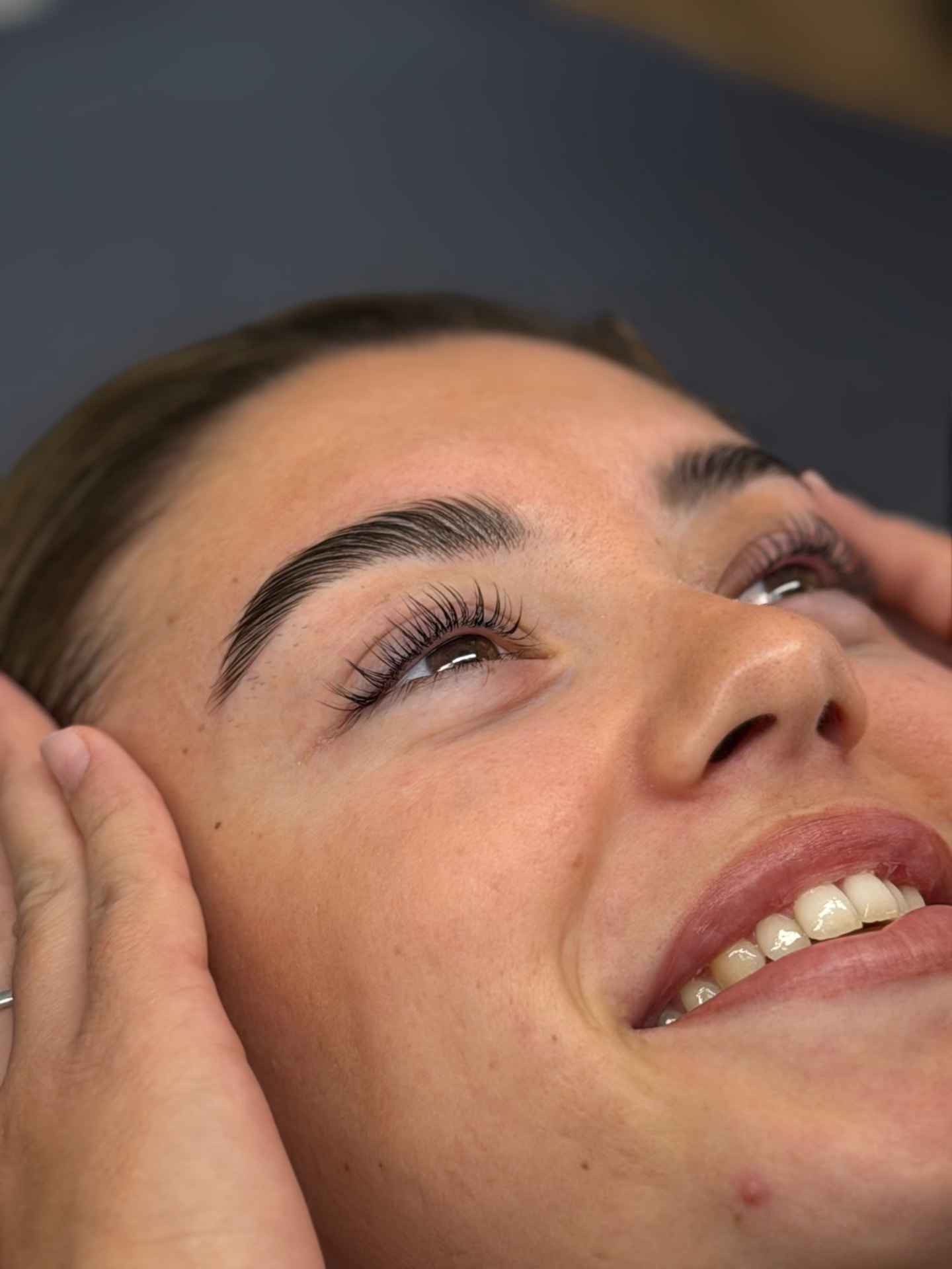 Clienta sonriendo con el resultado de sus pestañas Yumi